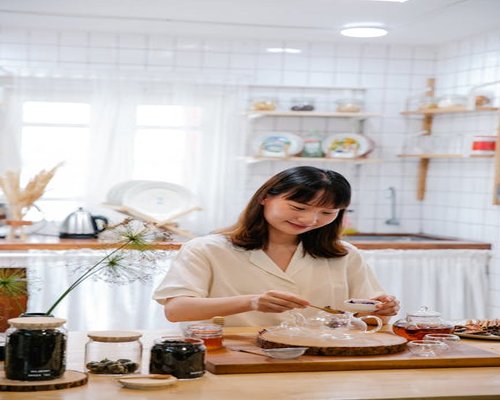 Person preparing tea in a modern Malaysian apartment kitchen in the morning